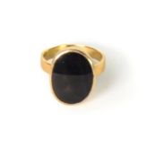 14K GOLD RING, collet set with an oval, slightly transluscent, black stone, 5.2gms, ring size L