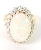 18ct GOLD OPAL AND DIAMOND CLUSTER RING with a large oval opal in a round multi claw setting and