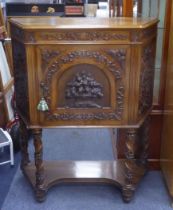 A PROFUSELY CARVED WALNUT CONTINENTAL SIDE CABINET, broad canted forecorners, on four spiral legs