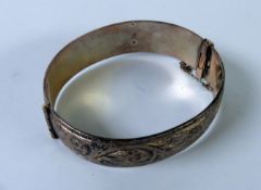 SOLID STERLING HINGE-OPENING BANGLE with foliate scroll engraved top, 1 1/2ozs