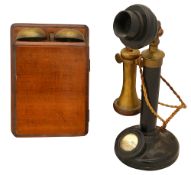 A black metal, bakelite and brass candlestick telephone