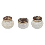 Three silver mounted tortoiseshell and pique inlaid lidded cut glass dressing pots