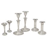 Two pairs of Edwardian silver candlesticks and a pair of spill vases