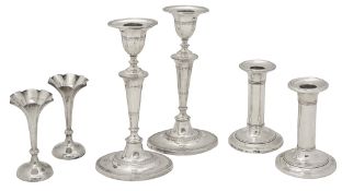 Two pairs of Edwardian silver candlesticks and a pair of spill vases