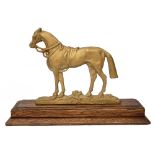 A gold painted cast metal figure of a horse mounted on an oak plinth base