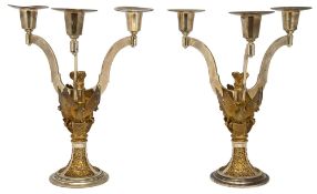 A pair of silver and parcel-gilt three branch candelabra