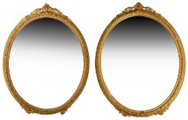 A pair of late 19th century gilt gesso framed oval mirrors