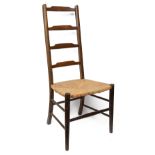 An Arts and Crafts stained beech rushed seated ladderback bedroom chair