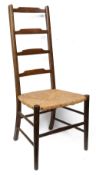 An Arts and Crafts stained beech rushed seated ladderback bedroom chair