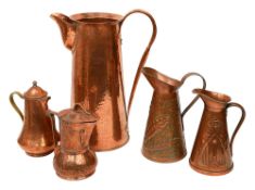 An Arts and Crafts hammered copper ewer and four other jugs