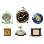 A 1930s enamel and brass alarm clock, five others