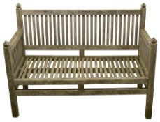 A weathered teak garden bench