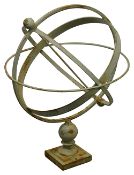A pale green cast metal armillary sphere