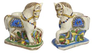 Two Persian Qajar polychrome glazed pottery horse candlesticks
