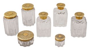 Seven early Victorian silver-gilt mounted cut glass toilet bottles and jars