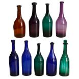 A collection of early 19th century coloured glass bottle shaped decanters