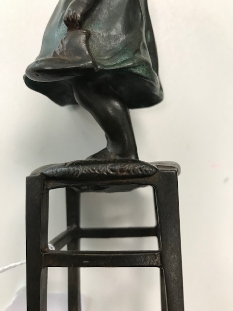 A bronze figure of a young girl standing on a stool - Image 2 of 4