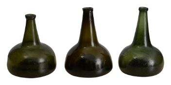 Three early 18th century onion shaped green glass wine bottles