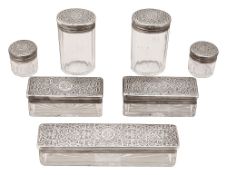 Seven late Victorian silver topped cut glass toilet jars