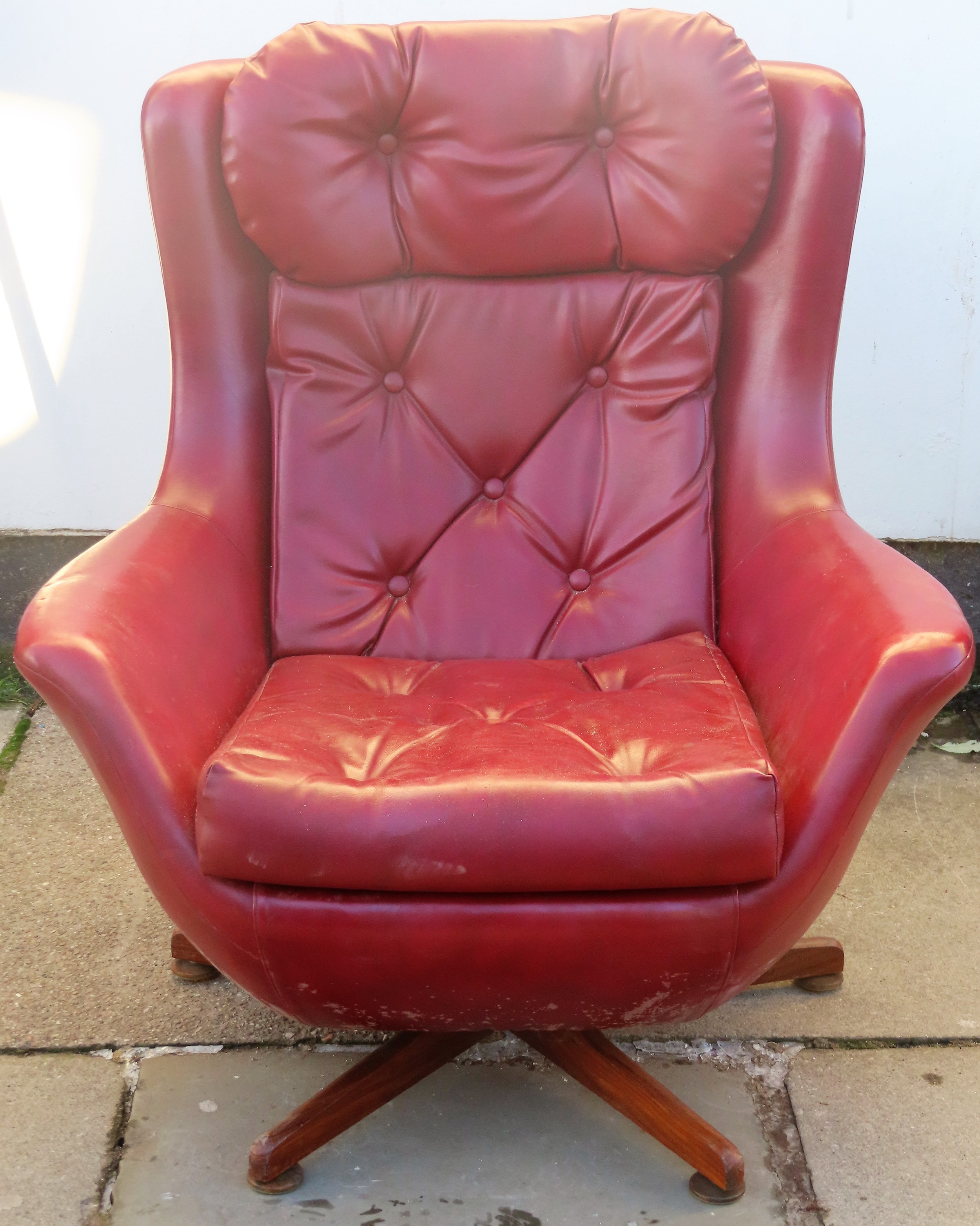 Mid 20th century Oxblood red leather effect swivel armchair on teak supports. Approx. 94cm H x