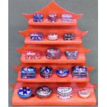 Wooden pagoda style stand containing enamelled pill boxes All in used condition, unchecked