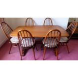 Ercol mid 20th century oak refectory style dining table, plus 6 stick back dining chairs. Table