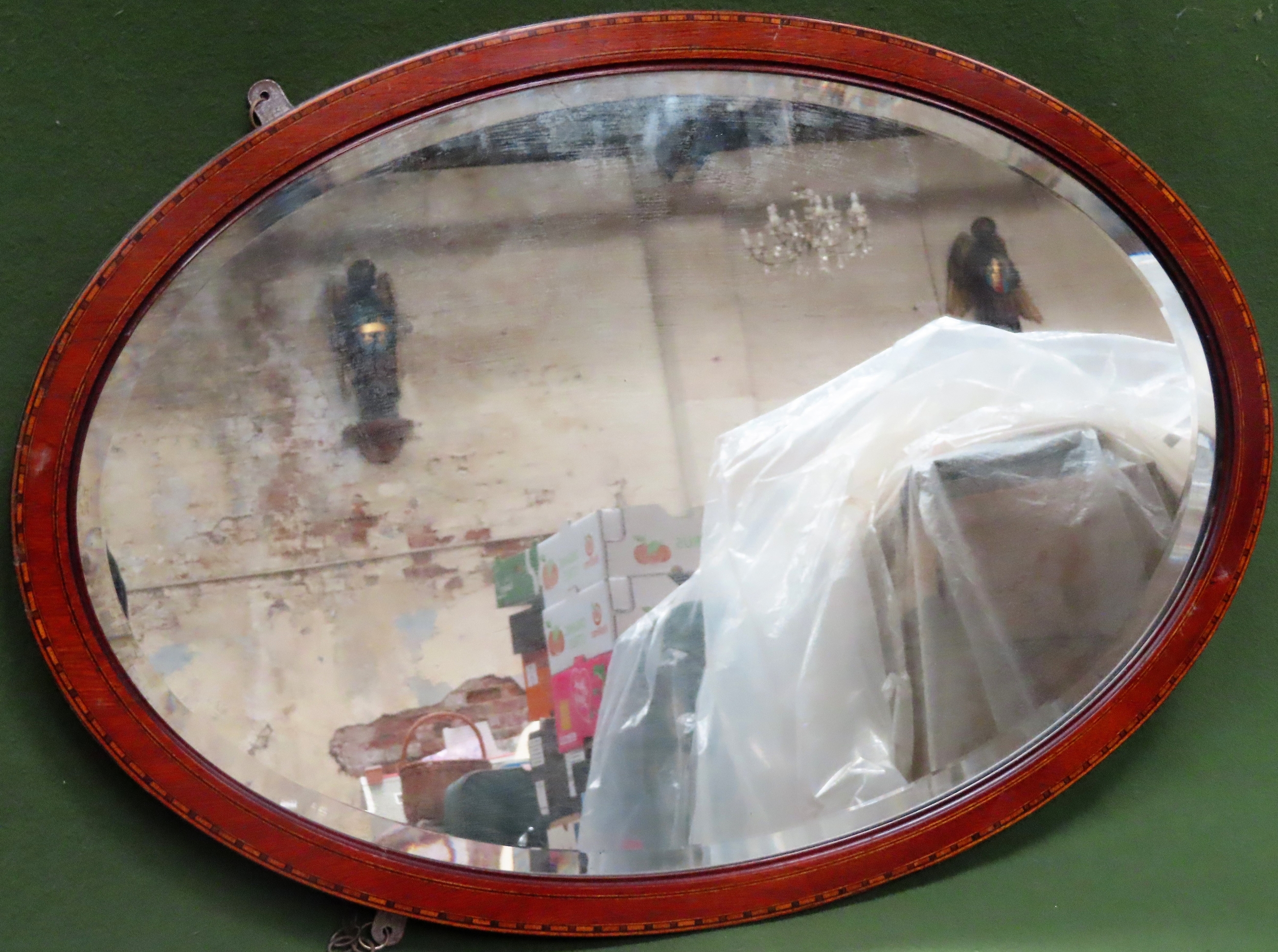 Mahogany bevelled and inlaid oval wall mirror. App. 57 x 82cm Appears in reasonable used condition