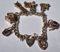 HALLMARKED SILVER CHARM BRACELET WITH EIGHT CHARMS AND HEART FORM CLASP. WEIGHT APP. 8.8g