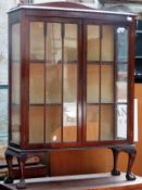 Early 20th century bowfronted two door display cabinet on ball and claw supports