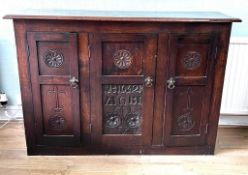 CARVED OAK THREE DOOR CUPBOARD BEARING PANEL 1642, APPROX 132cm LONG, 90cm HIGH AND 38cm DEEP