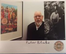 Peter Blake signed photograph of him with various Sgt Pepper images