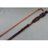 Interesting hand carved tribal style walking stick, plus another walking stick. Approx. 96cms L