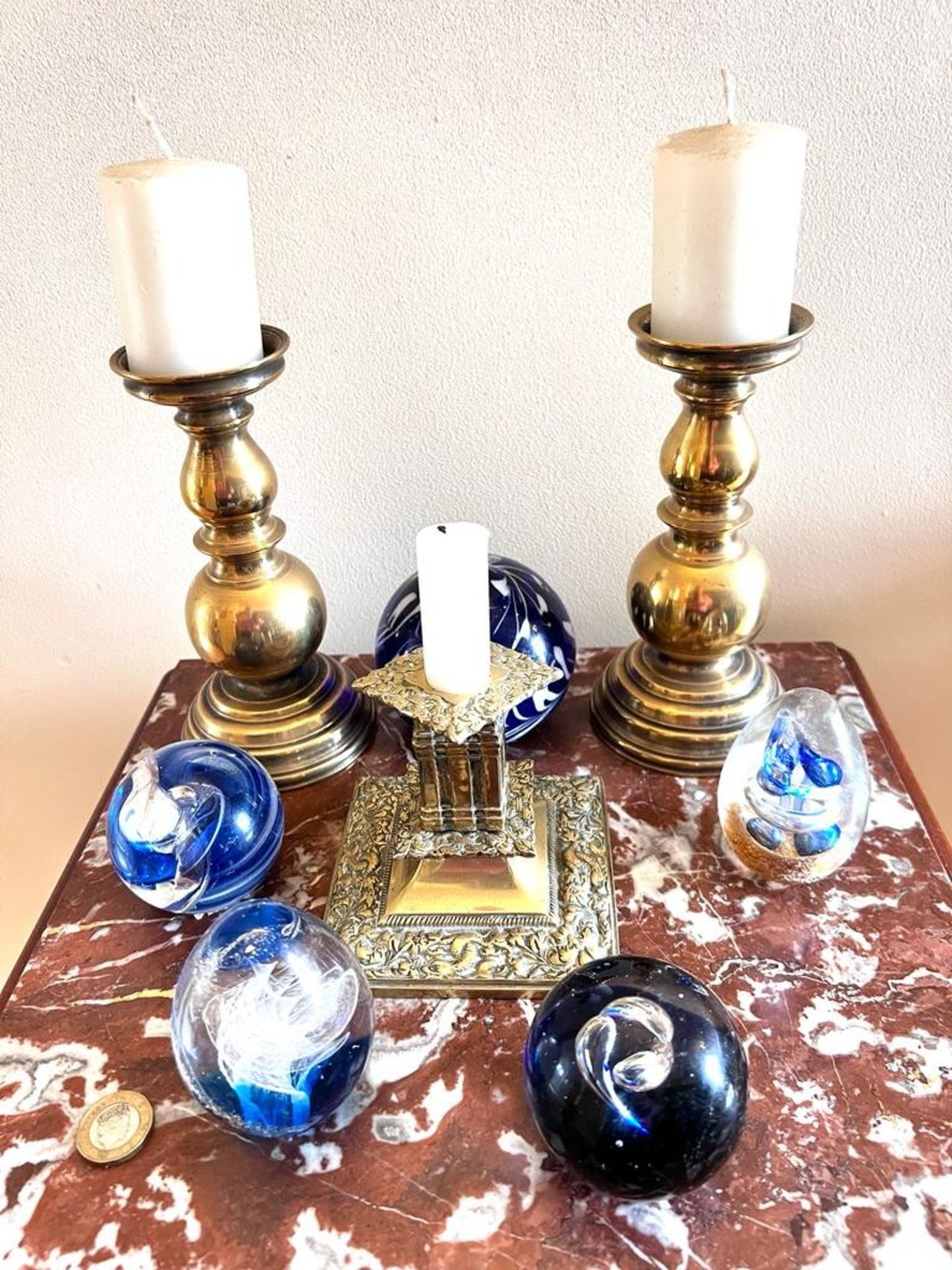 PAIR OF BRASS CANDLESTICKS AND A BRASS CANDLE HOLDER, AND FIVE PAPERWEIGHTS