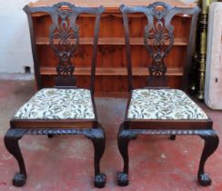Pair of 20th century mahohany piercework decorated ding chairs on ball and claw supports. Approx.