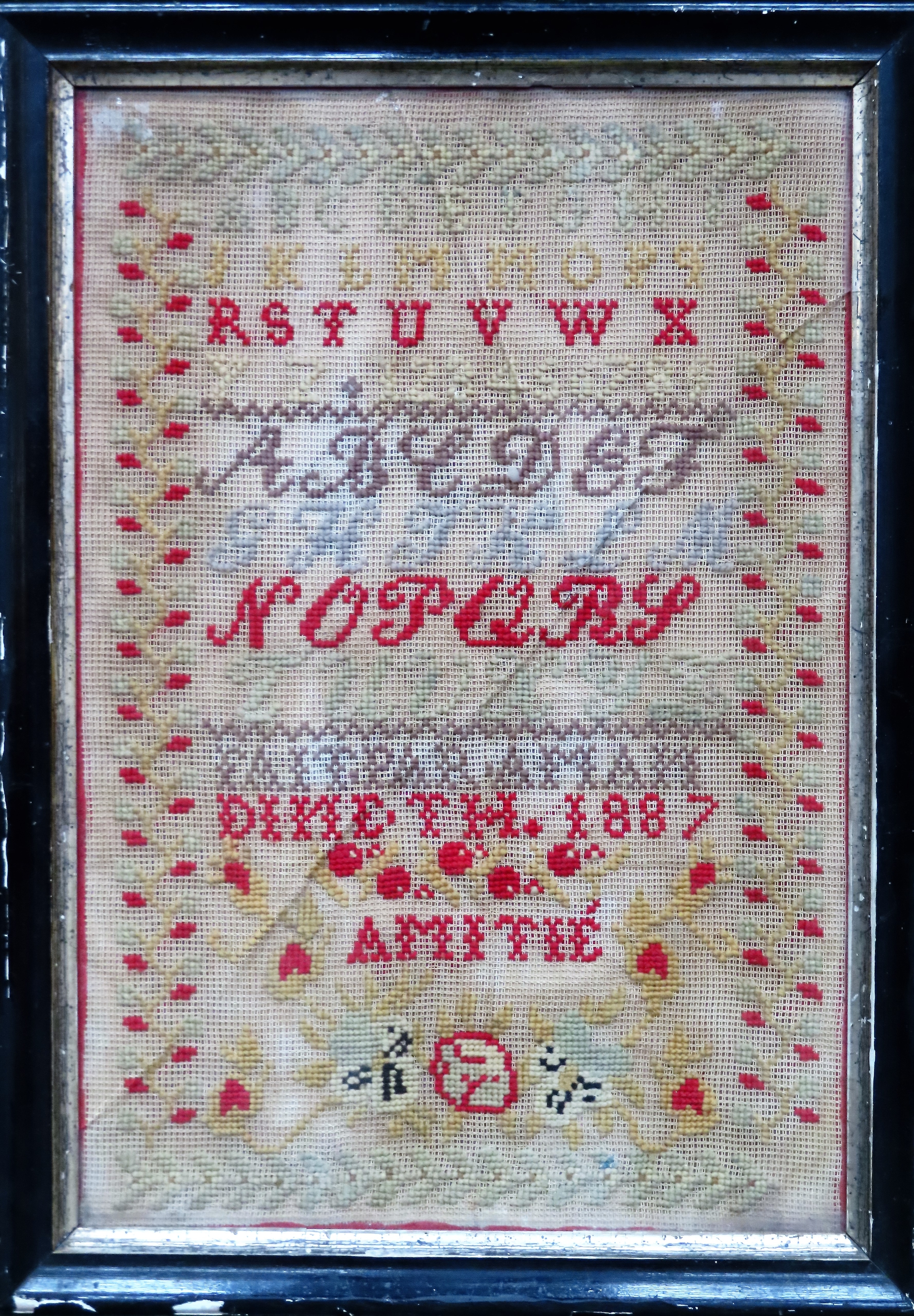Ebonised framed 1887 sampler. Approx. 43.5 x 29cms used with discolouration. glass cracked