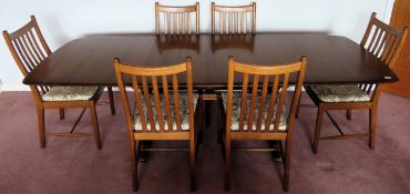 Ercol mid 20th century oak extending dining table, with three leaves and six dining chairs.