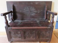 19th century dark oak monks bench with lift up seat and carved decoration. Approx. 99 x 122 x