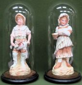 Pair of continental glazed and unglazed bisque figures, underneath Victorian glass domes