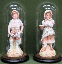 Pair of continental glazed and unglazed bisque figures, underneath Victorian glass domes