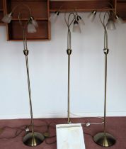 Three 20th century three sconce standard lamps, with glass shades, plus three spare shades.