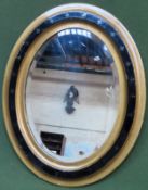 Gilded, ebonised and bevelled gothic style oval wall mirror. Approx. 53 x 43 Used condition,