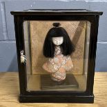 A cased Japanese doll, case size 24 x 20 x 27cm.