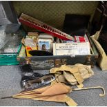 A metal trunk and contents including books, postcards, ice skates etc.