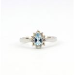 An 18ct white gold ring set with a pear cut aquamarine surrounded by brilliant cut diamonds, (M).