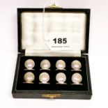 A cased set of eight hallmarked silver place markers, H. 2cm.