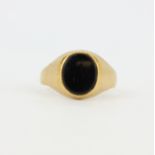 A gentleman's hallmarked 9ct yellow gold onyx set signet ring, (U). Slight bend to shank.