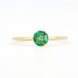 An 18ct yellow gold (stamped 750) ring set with marquise cut emeralds and a brilliant cut