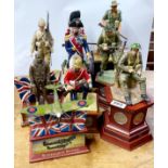 A group of military commemorative figures, mostly with coins, tallest H. 35cm.