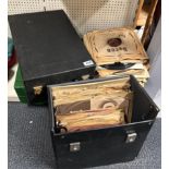 A portable wind up record player with a quantity of 78 RPM records.