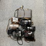 A group of mixed cameras and binoculars.